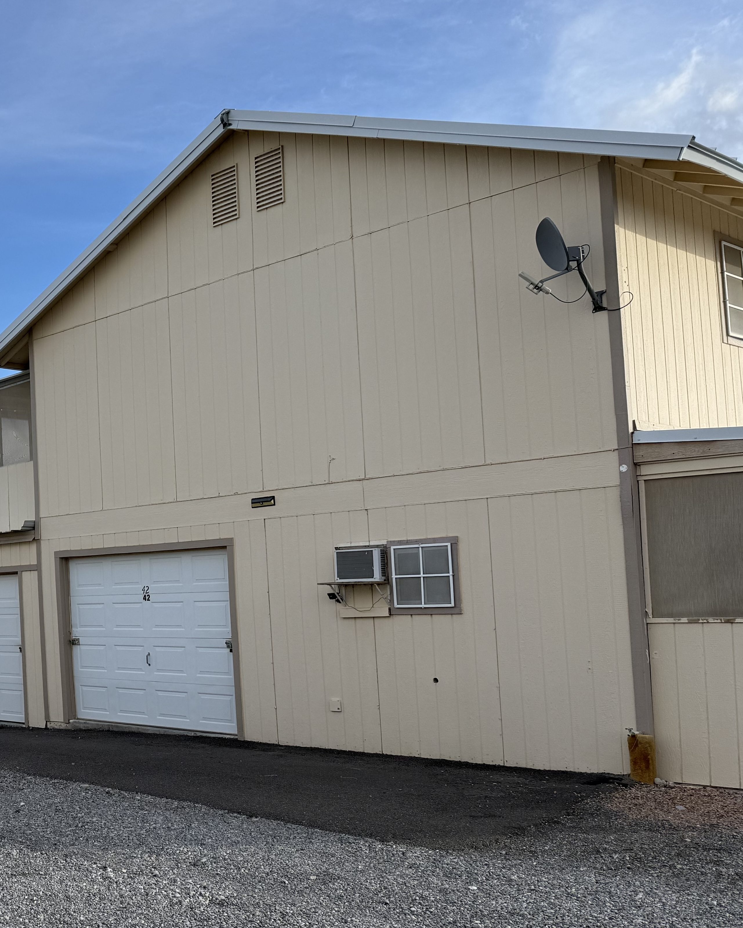 The two-story building at Decroff Storage Units, with a drive-up door at ground level and desert sky above.